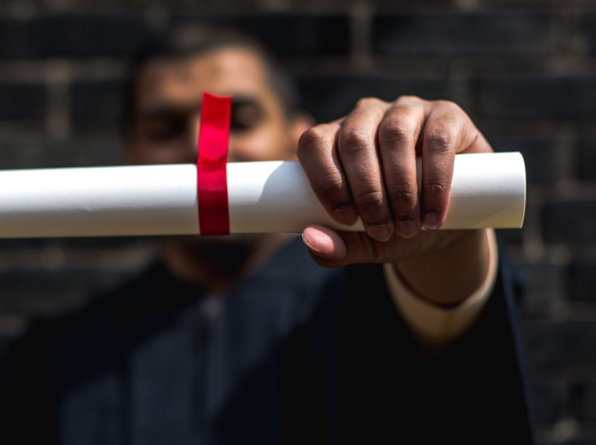 recent graduate holding diploma