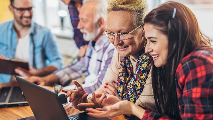 young volunteer teaching digital technology to senior